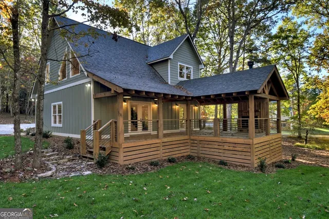 a view of a house with a small yard and wooden fence