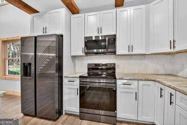 a kitchen with stainless steel appliances granite countertop a stove a refrigerator and a sink