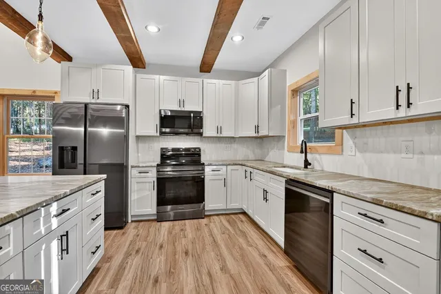 a kitchen with stainless steel appliances a stove a sink dishwasher a refrigerator and a stove