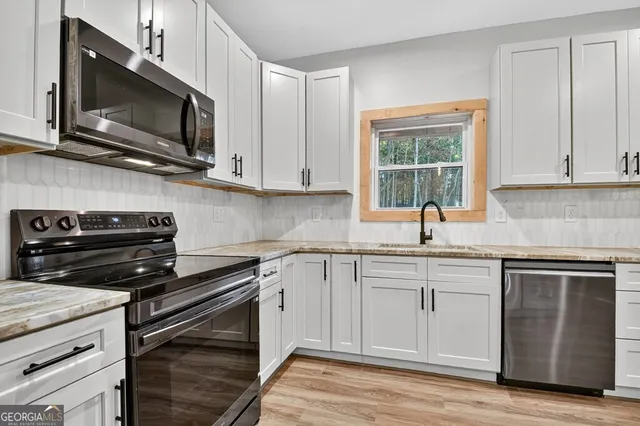 a kitchen with a sink stove and microwave