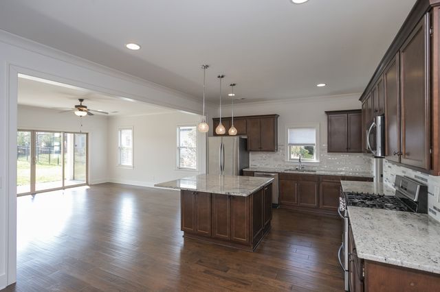 a large kitchen with a large window and stainless steel appliances