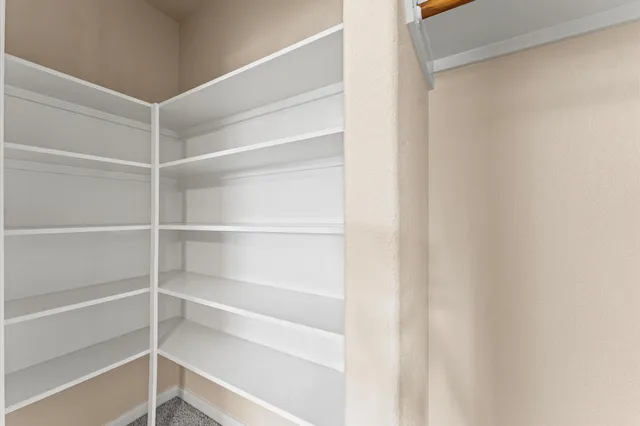 a view of walk in closet with empty racks