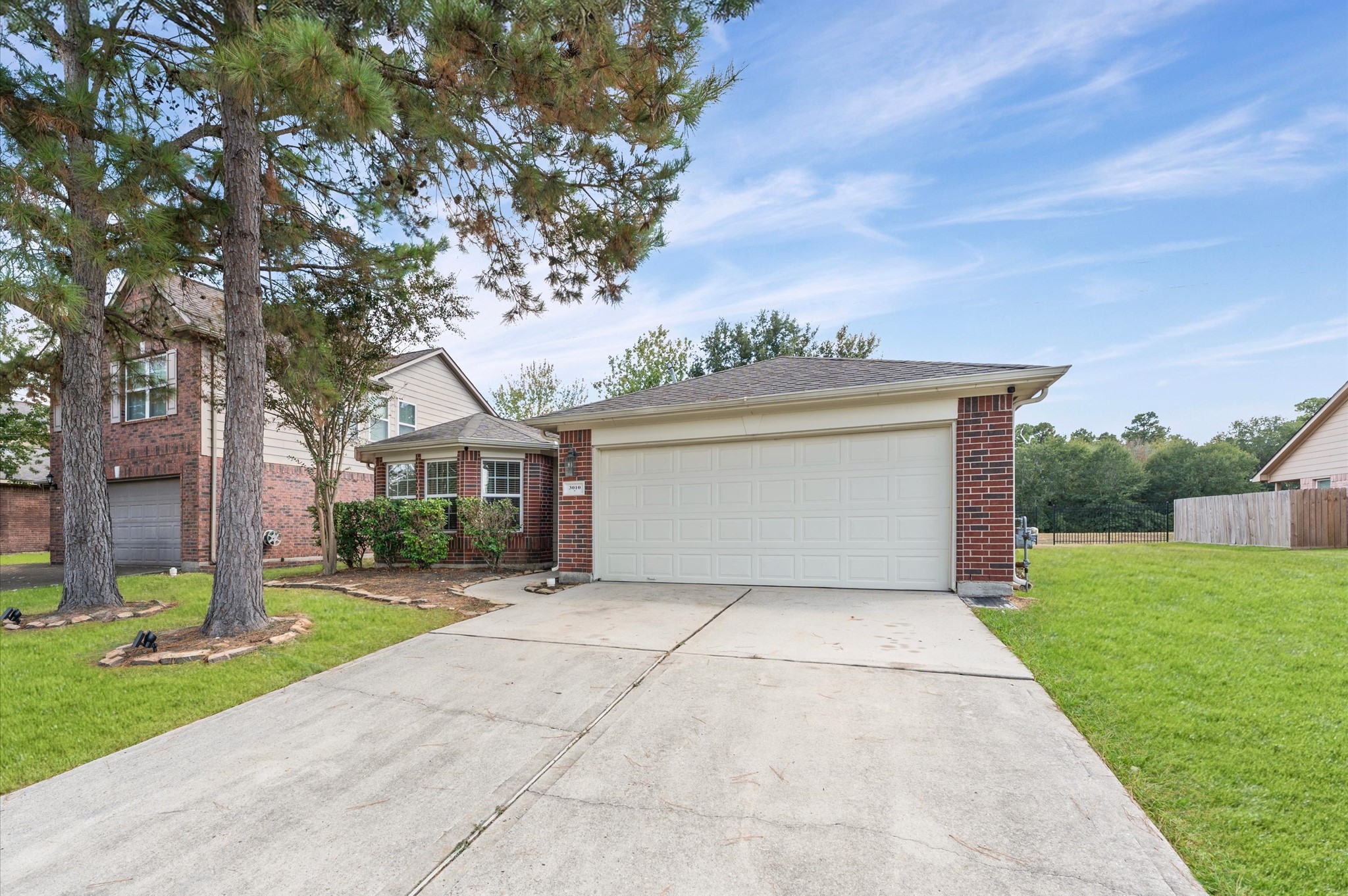 3010 Pathfinders Pass Spring, TX 77373 - Photo 3 of 26 a front view of a house with a garden and trees