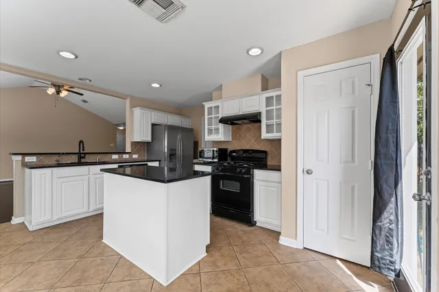 a kitchen with kitchen island a sink stainless steel appliances and cabinets