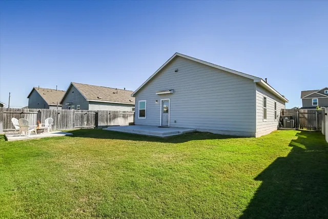 a backyard of a house with table and chairs