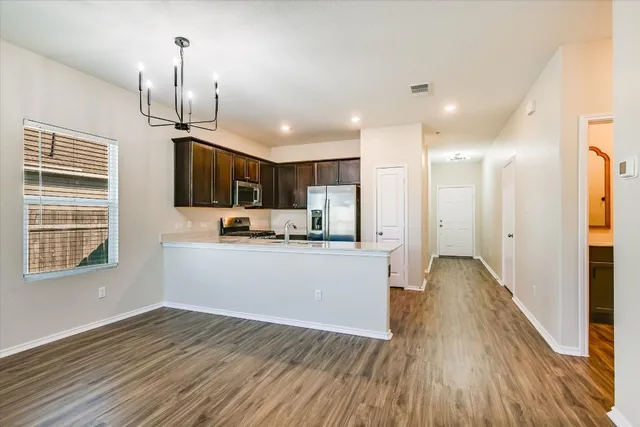 a view of kitchen with wooden floor electronic appliances and window