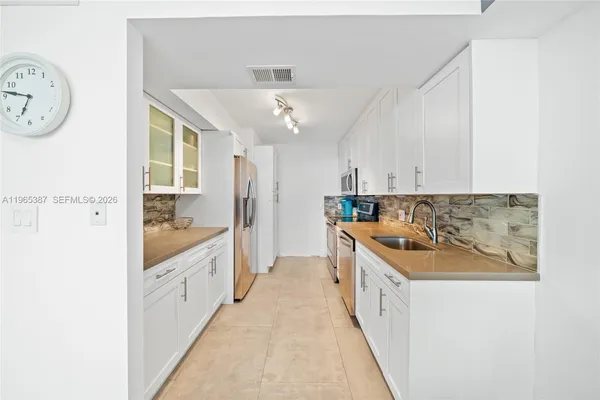 a kitchen with a refrigerator and a sink