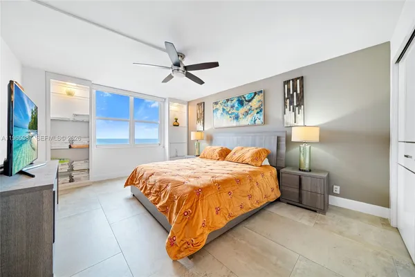 a bed room with a bed and painting on the wall