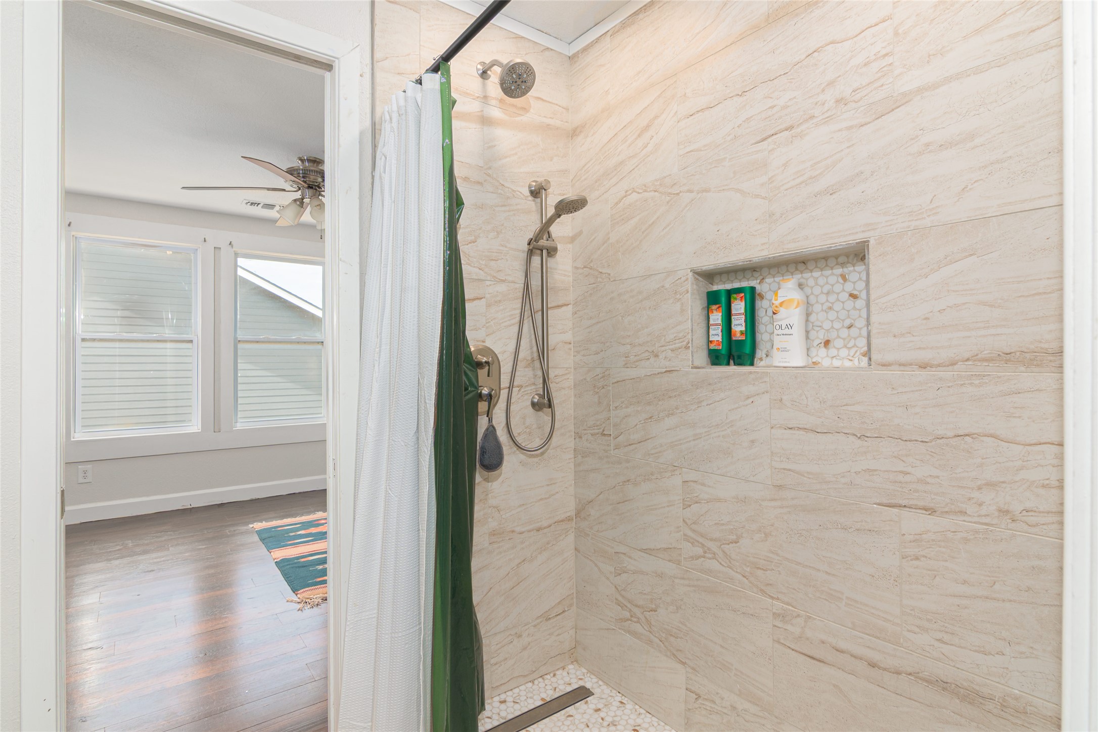 204 Prim Rose Road Blanco, TX 78606 - Photo 26 of 40 A modern walk-in shower features textured wall tile and a built-in storage niche.