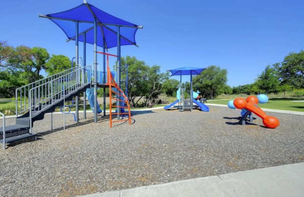 3625 Garrano Bend Leander, TX 78641 - Photo 35 of 38 Community playground featuring multiple play structures, a shade canopy, and a resilient ground surface