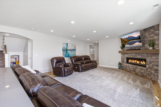 21 Pier Place Tooele, UT 84074 - Photo 50 of 112 Spacious recreation room featuring recessed lighting, a stone-clad fireplace with a wood mantel, and wood-finish flooring transitioning to carpet