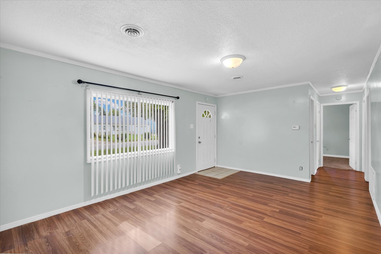 1345 Sunset Drive Rantoul, IL 61866 - Photo 3 of 22 a view of an empty room with wooden floor and a window