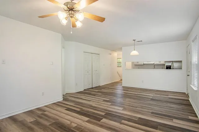 a view of a kitchen with wooden floor and a ceiling fan