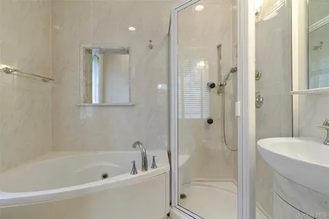 a bathroom with a tub shower vanity and a sink
