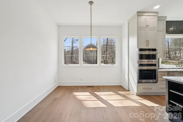 a view of a kitchen with wooden floor and electronic appliances