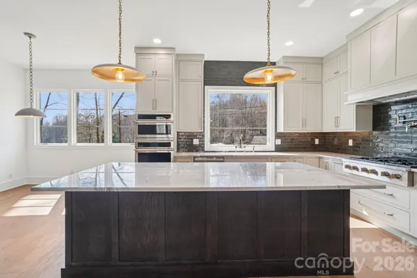 a kitchen with stainless steel appliances granite countertop a stove a sink and a refrigerator