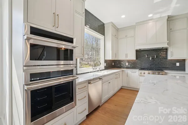 a kitchen with cabinets stainless steel appliances and sink