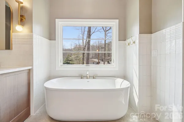 a white bath tub sitting in a bathroom next to a window