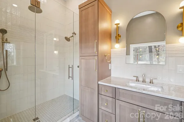 a bathroom with a double vanity sink mirror and shower
