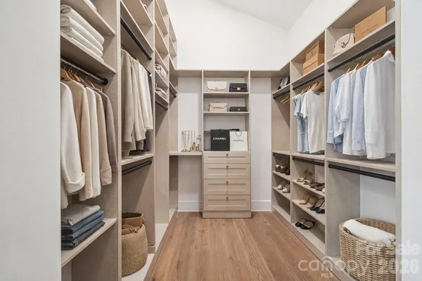 a view of walk in closet with clothes and shoes