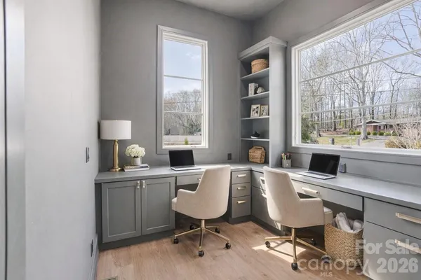 a view of a workspace with furniture and a window