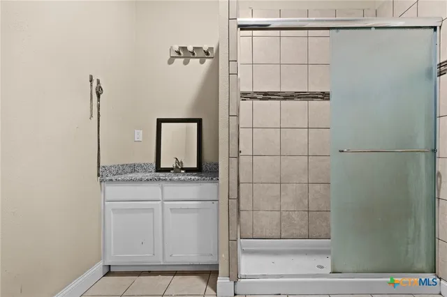 a bathroom with a granite countertop sink a vanity and shower