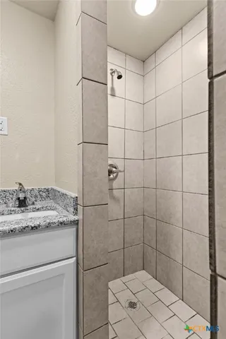 a bathroom with a granite countertop sink toilet and shower