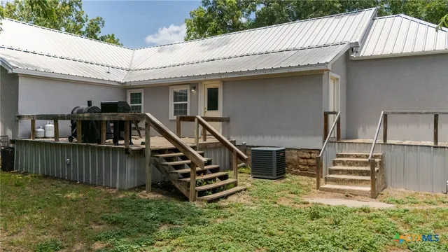 a view of house with a roof deck and furniture