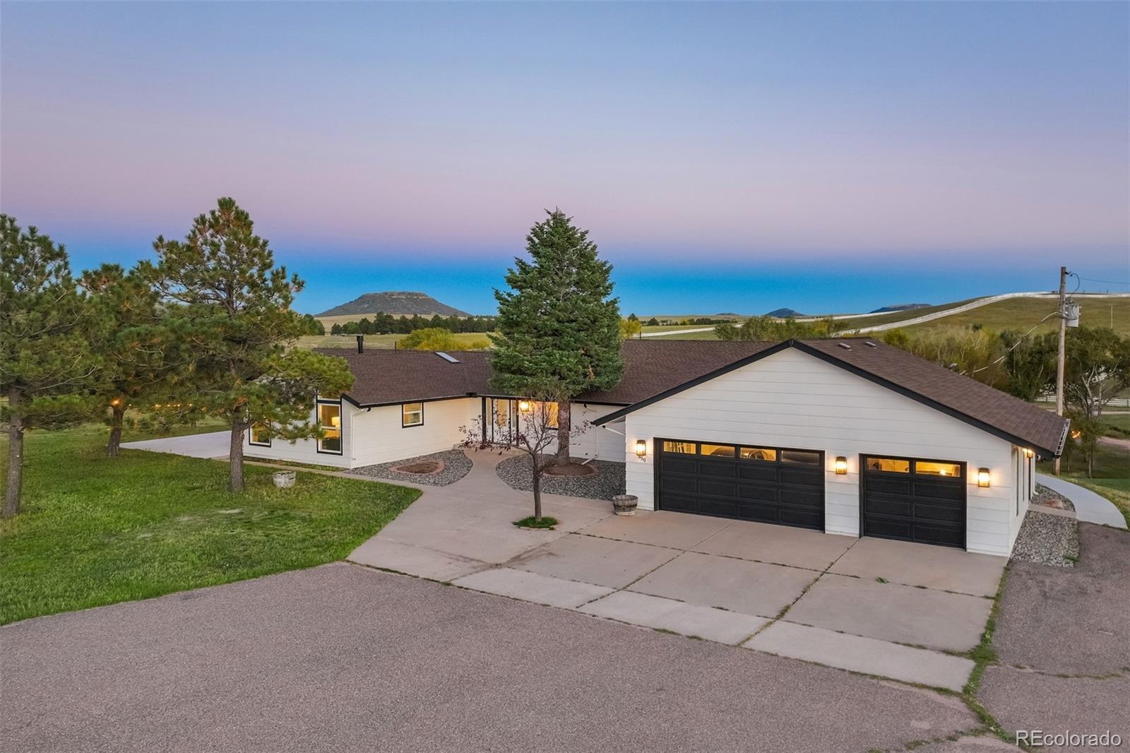 850 West Fox Farm Road Larkspur, CO 80118 - Photo 22 of 50 a front view of a house with a yard and garage