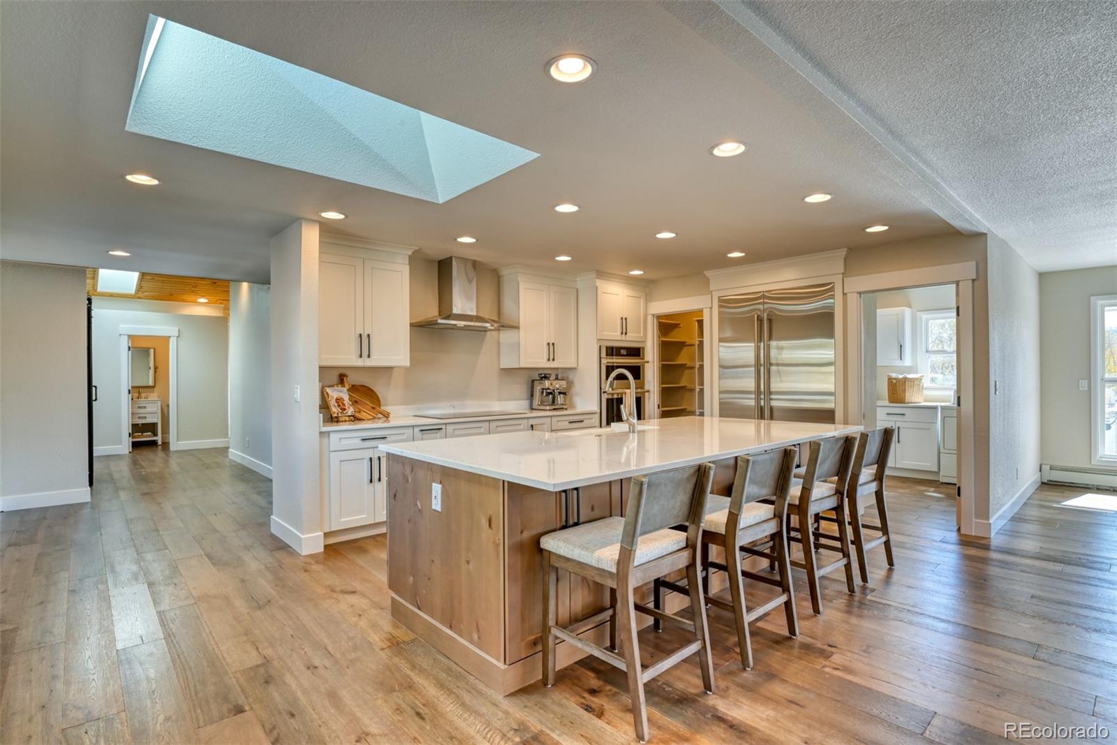 850 West Fox Farm Road Larkspur, CO 80118 - Photo 24 of 50 a kitchen with a dining table chairs wooden floor appliances and cabinets