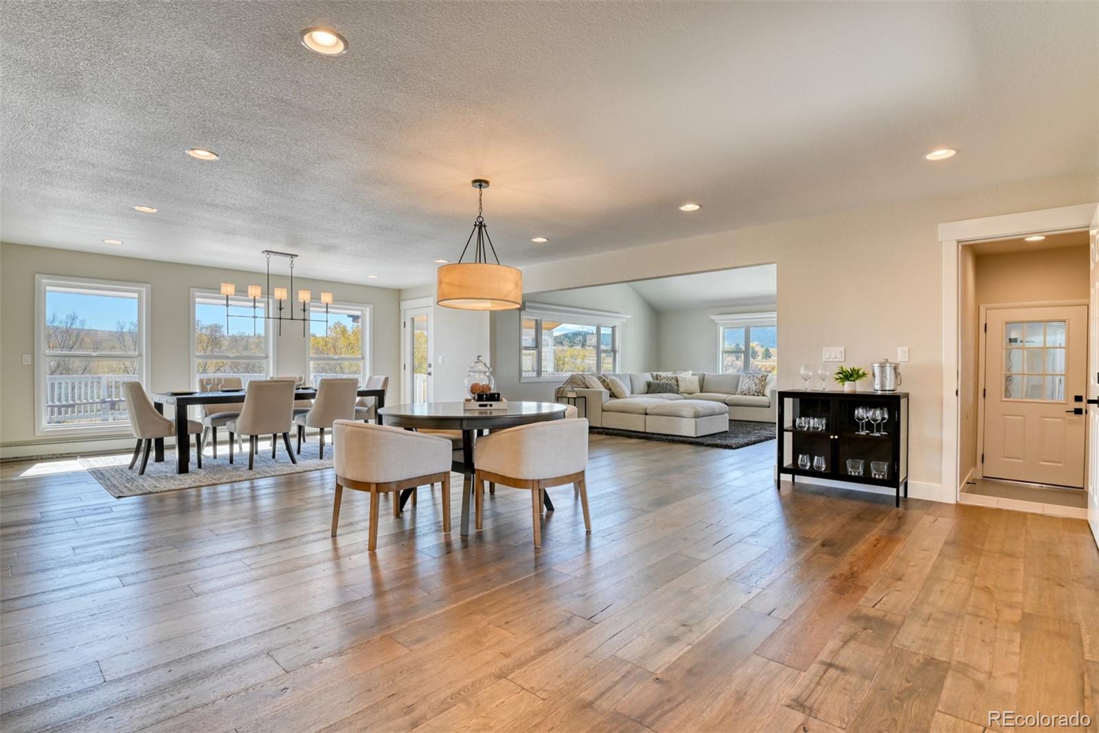 850 West Fox Farm Road Larkspur, CO 80118 - Photo 26 of 50 a view of dining room and livingroom with furniture wooden floor a chandelier