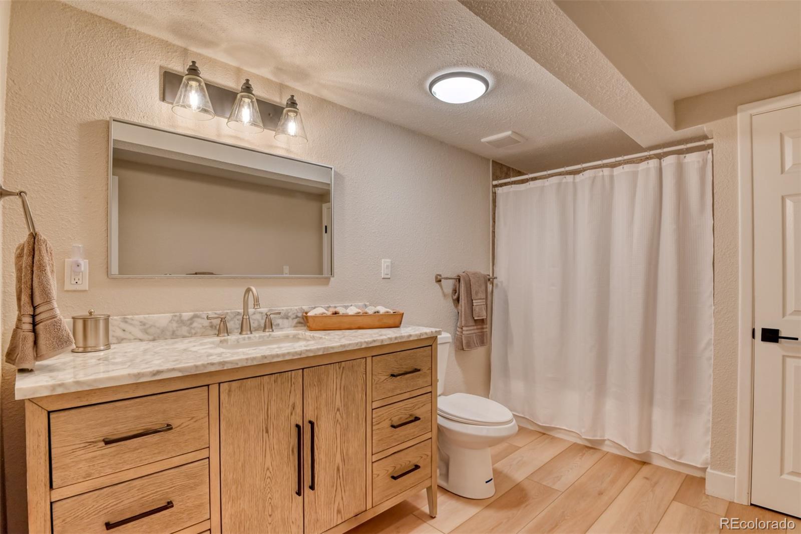 850 West Fox Farm Road Larkspur, CO 80118 - Photo 40 of 50 a bathroom with a toilet sink and mirror