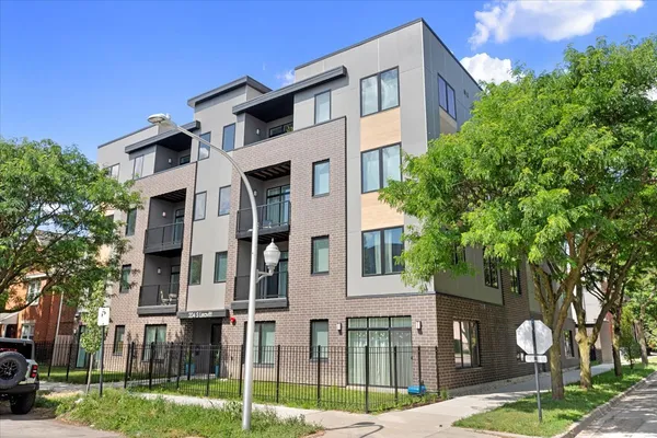 a front view of a residential apartment building with a yard