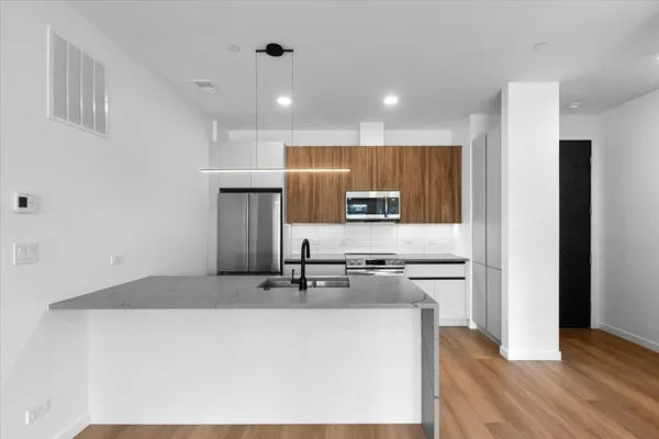 a kitchen with stainless steel appliances granite countertop a sink a stove and a refrigerator