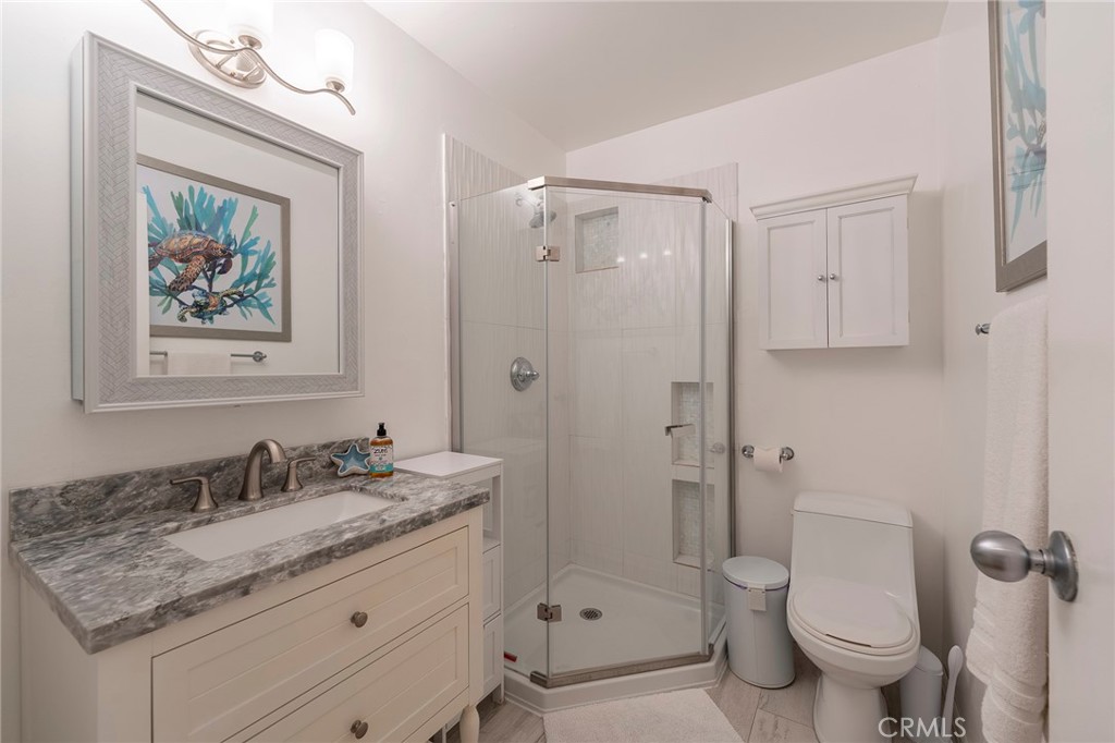 1728 The Strand, Unit 1 Hermosa Beach, CA 90254 - Photo 15 of 16 a bathroom with a granite countertop sink toilet and shower