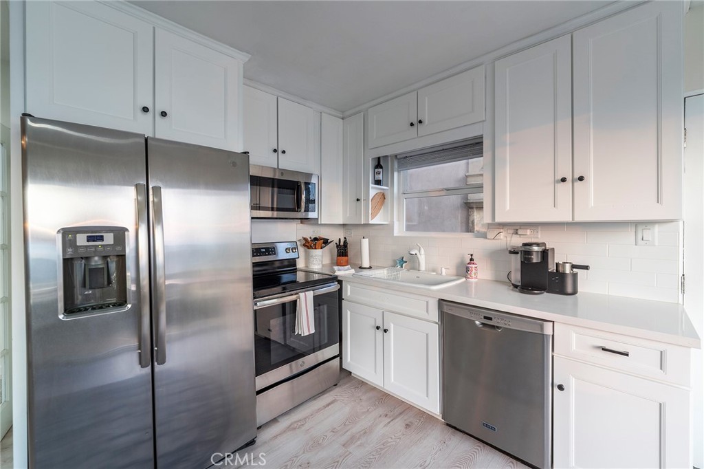 1728 The Strand, Unit 1 Hermosa Beach, CA 90254 - Photo 6 of 16 a kitchen with stainless steel appliances cabinets and a refrigerator