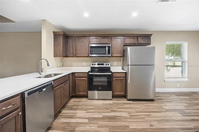 a kitchen with a refrigerator and a stove top oven