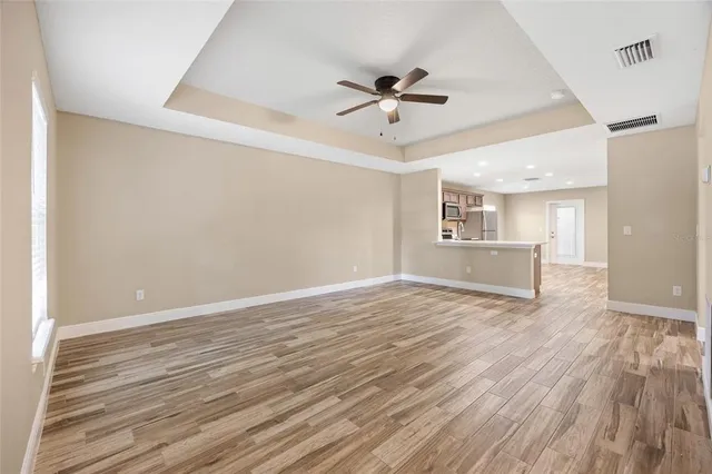 a view of a livingroom with wooden floor and a ceiling fan