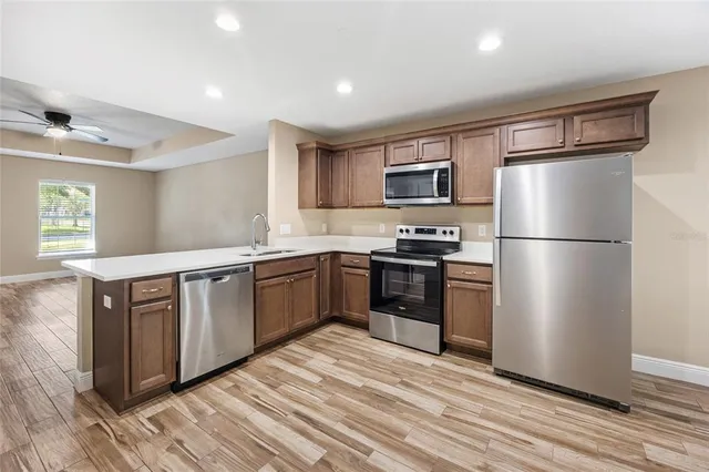 a kitchen with granite countertop stainless steel appliances a refrigerator cabinets and a counter space