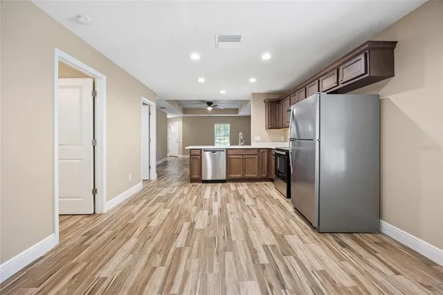 a view of kitchen with refrigerator microwave and wooden floor