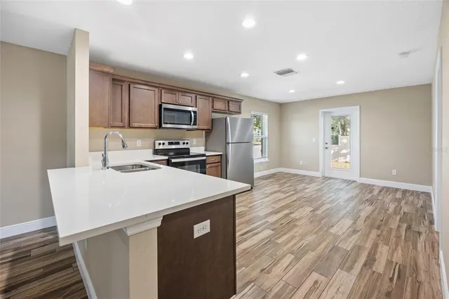 a kitchen with a sink a stove a refrigerator and cabinets