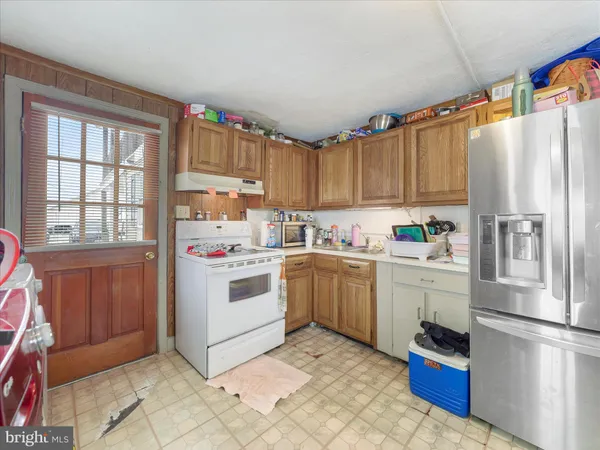 a kitchen with a refrigerator and a stove top oven