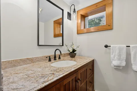 a bathroom with a granite countertop sink and a mirror
