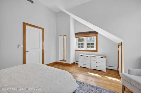 a spacious bedroom with a bed a table and a window