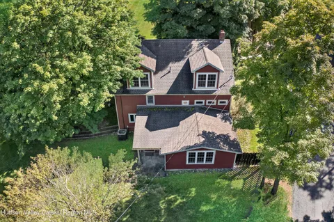an aerial view of a house with a big yard and large trees