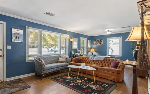 a living room with furniture a table and a large window