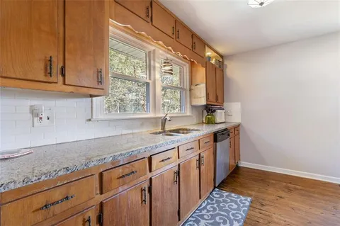 a kitchen with granite countertop a sink a stove and cabinets