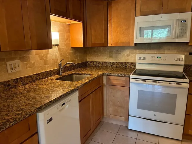 a kitchen with stainless steel appliances granite countertop a sink stove and cabinets