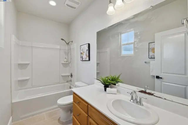 a bathroom with a granite countertop sink toilet a large mirror a shower and bathtub