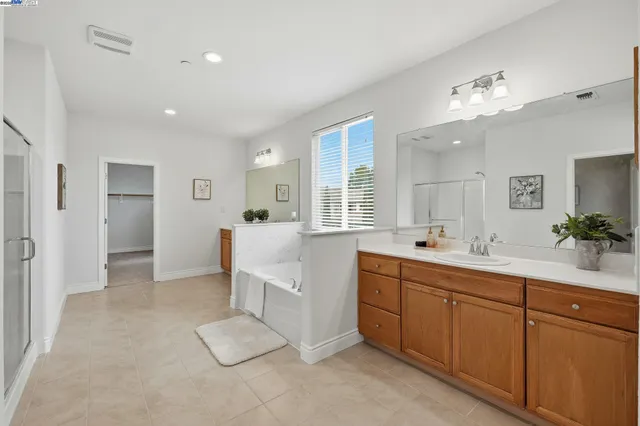 a large white kitchen with a sink and dishwasher with white cabinets